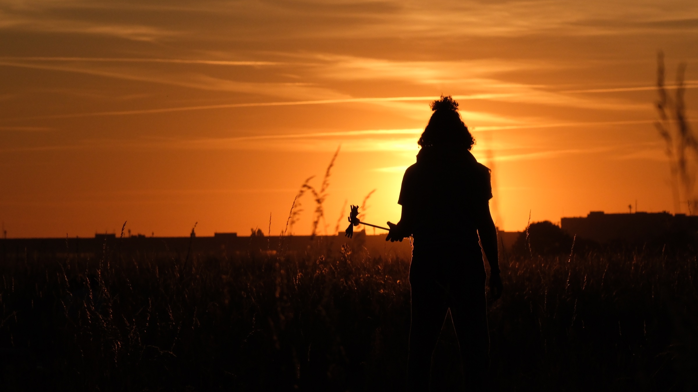 Silhouette eines Menschen im warmen Abendlicht auf dem Tempelhofer Feld in Berlin